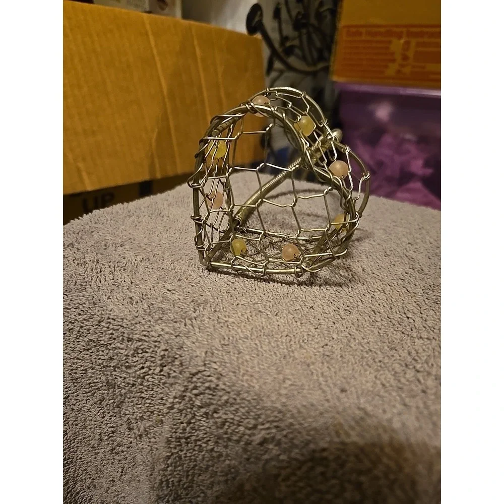 silver-tone wire basket featuring a heart-shaped base and a‎ coiled wire handle